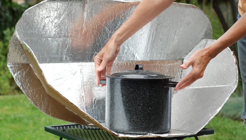 someone using a solar cooker