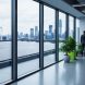 View from a modern office looking out at rooftop solar panels and a distant wind turbine, symbolizing ESG-aligned renewable energy integration and clean power strategy.
